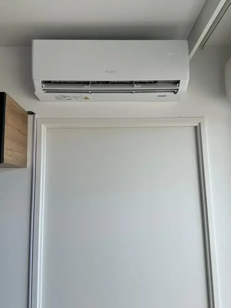 Split air conditioning system installed above doorway